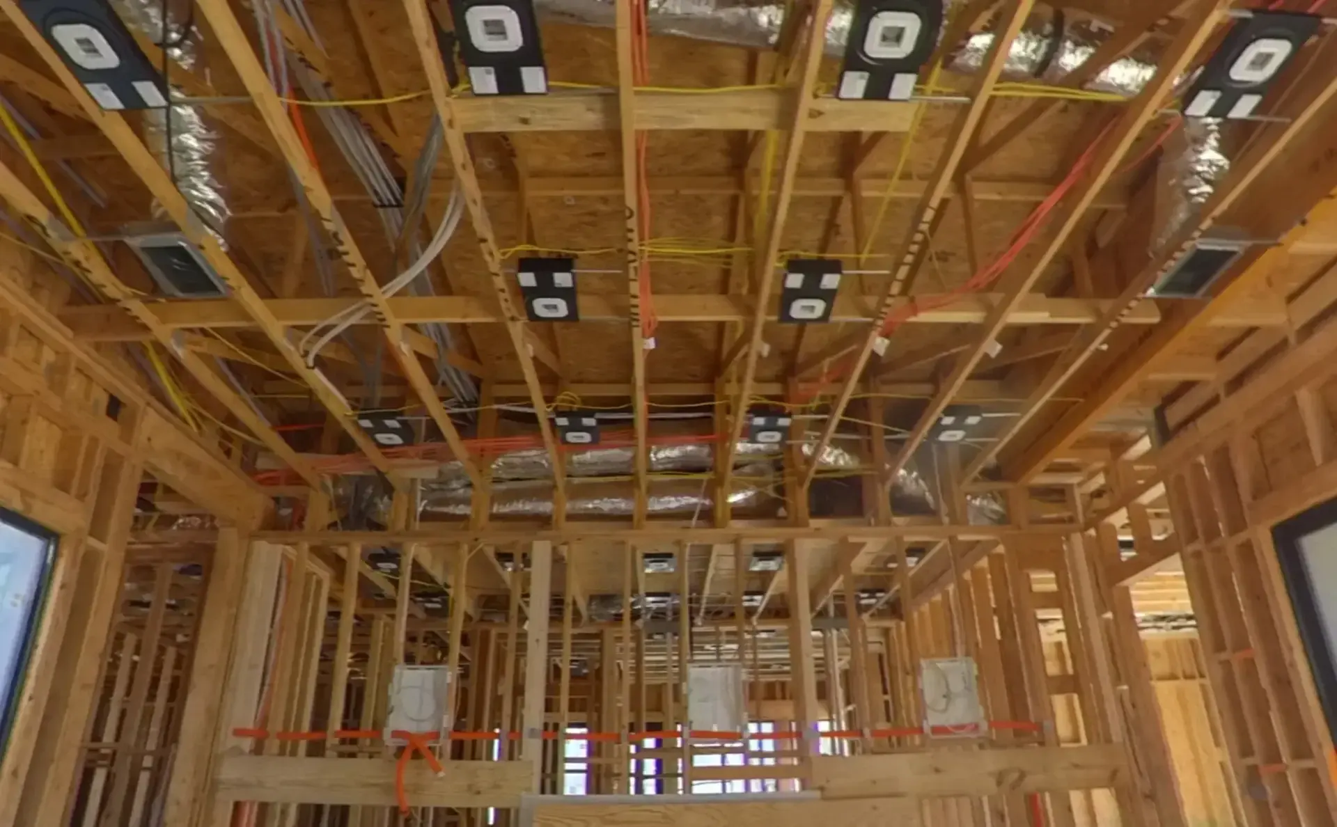 Open ceiling framing with wall boxes and low-voltage cable runs during rough-in. Home prewiring and structured wiring in Bee Cave, TX by AV Connect.