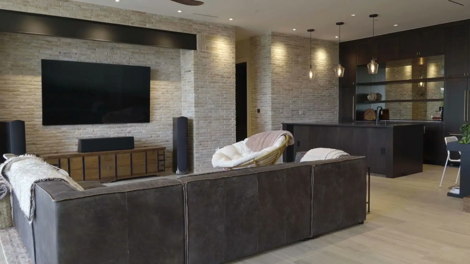 Open-plan Austin living room with a large display, architectural speakers, and a media bar, by AV Connect