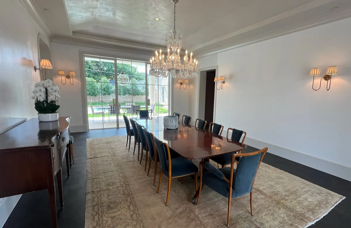 Formal dining room with a crystal chandelier and sconce lighting in a luxury Austin, TX home