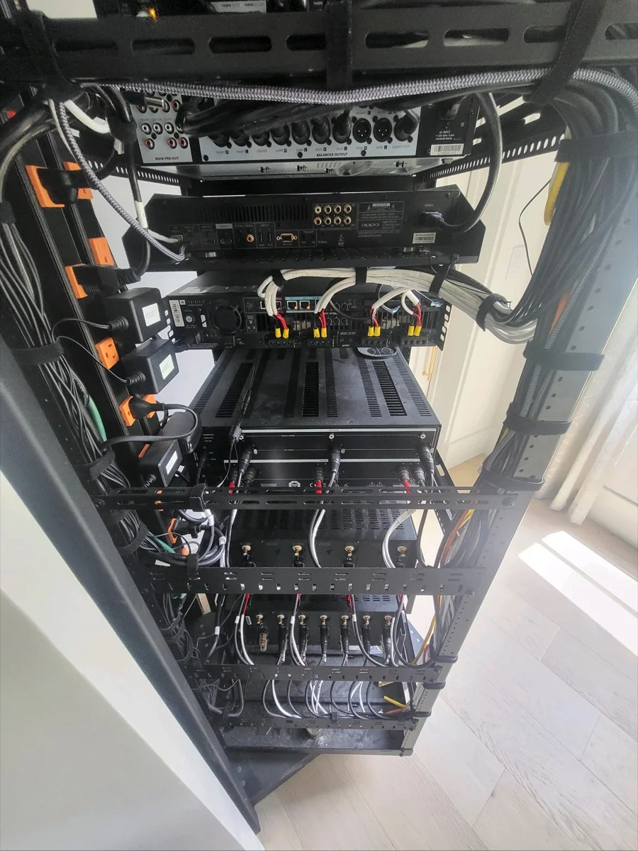 A structured AV equipment rack with organized amplifiers, networking, and cabling in an Austin, TX home