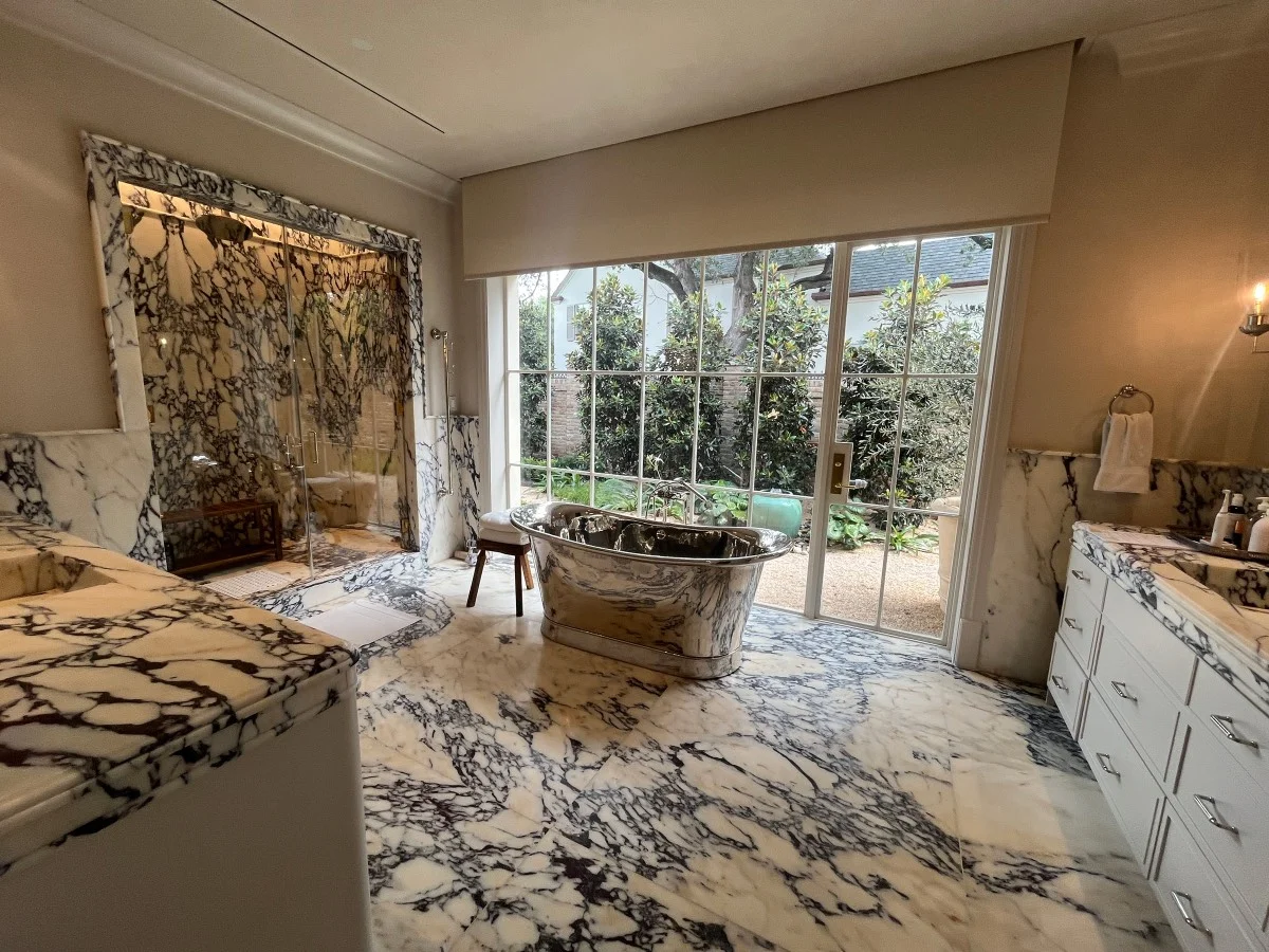 Luxury marble bathroom with motorized window shades and lighting in an Austin, TX home