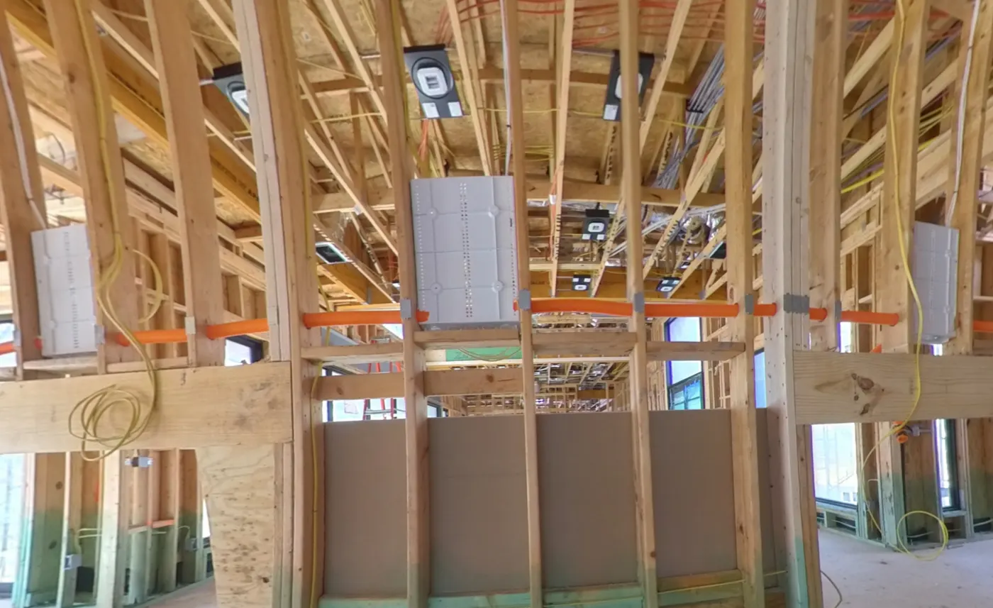Open framing across a whole-home prewire, with wall boxes and home-run wiring staged for a media wall, by AV Connect in Austin, TX