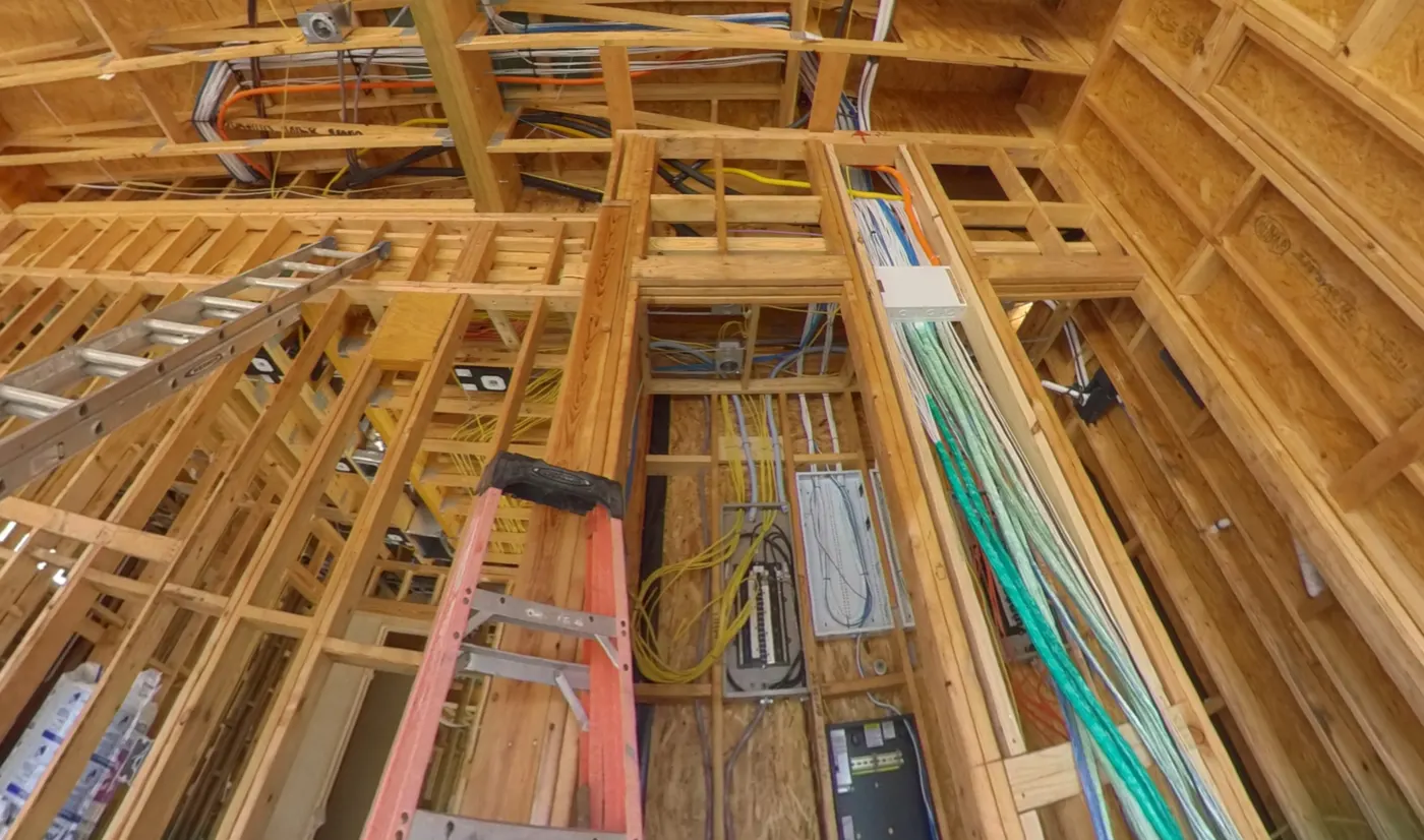Low-voltage wiring run through open wall framing to a rack room, staged before drywall, by AV Connect in Austin, TX