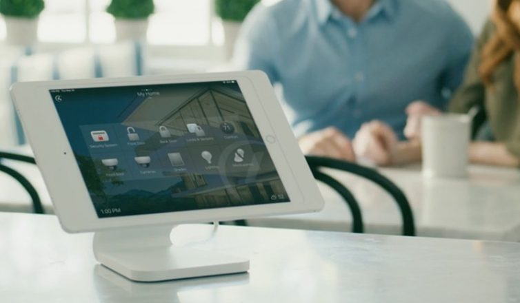 a control4 touchpad with a smart home interface is prominently displayed on a kitchen counter.