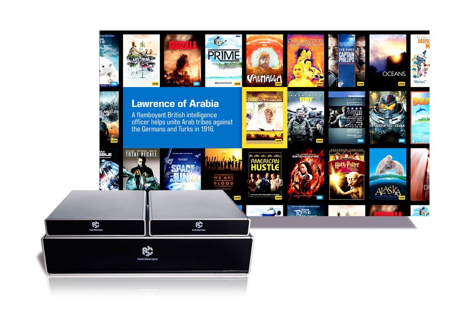 image of kaleidescape strato movie player and terra movie server with a background displaying a grid of movie covers, including 'lawrence of arabia' highlighted in the center.