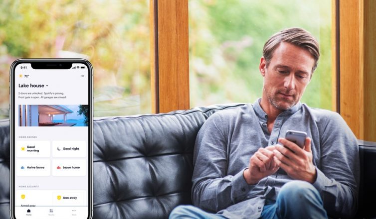 a man using a smartphone to control his smart home system in austin, texas, with the crestron home app visible.