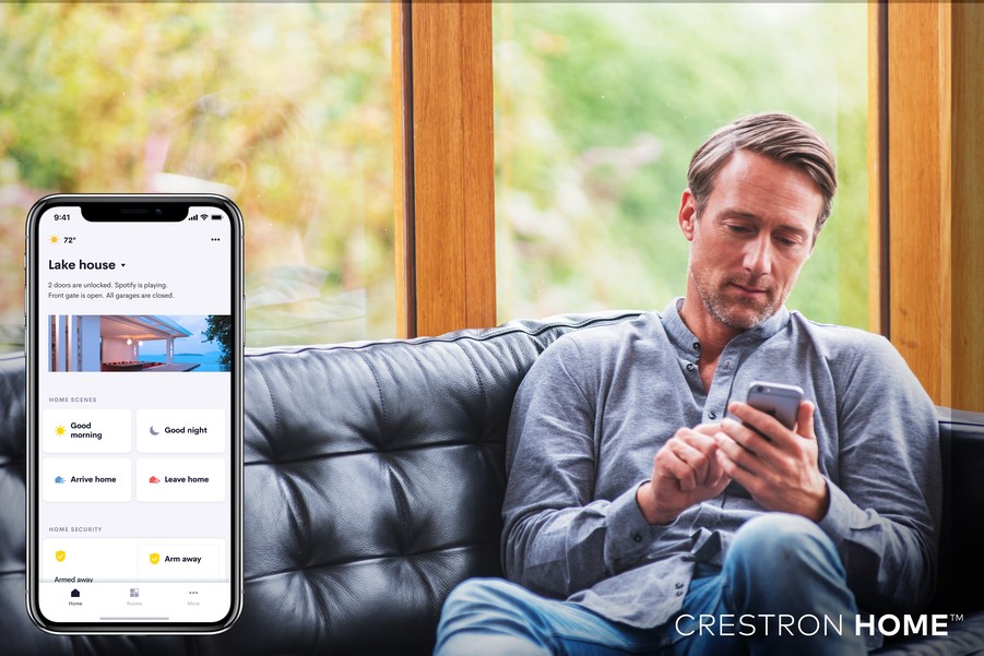 a man using a smartphone to control his smart home system in austin, texas, with the crestron home app visible.