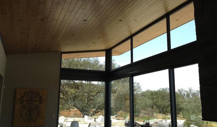 james small aperture speakers in a wooden ceiling of a large dining space overlooking the outdoors