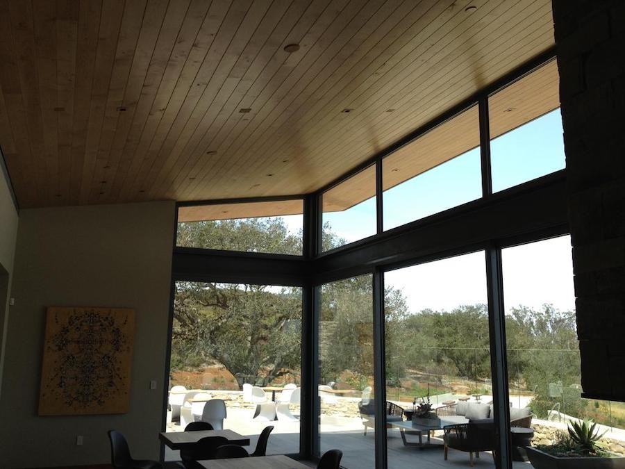 james small aperture speakers in a wooden ceiling of a large dining space overlooking the outdoors